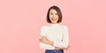 Confident business expert. Beautiful young woman in smart casual wear keeping arms crossed and smiling while standing against pink Royalty Free Stock Photo