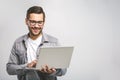 Confident business expert. Confident young handsome man in shirt holding laptop and smiling while standing against white Royalty Free Stock Photo