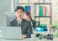 Confident business man working with laptop computer in office, front view with team in background Royalty Free Stock Photo