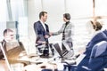 Confident business people shaking hands in moder corporate office. Royalty Free Stock Photo