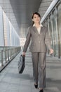 Confident business woman holding briefcase and walking Royalty Free Stock Photo