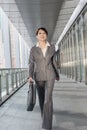 Confident business woman holding briefcase and walking Royalty Free Stock Photo