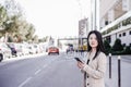 Confident business woman listening to music on headphones and mobile phone crossing street in city Royalty Free Stock Photo