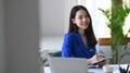 Business woman sitting in front of laptop computer at office desk and smiling at camera. Royalty Free Stock Photo