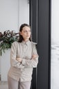 confident business woman stands at window in office looking into distance. thoughtful female Royalty Free Stock Photo