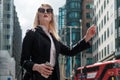 Confident business woman waving a taxi in city of London Royalty Free Stock Photo