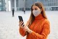 Confident business woman wearing protective face mask calling with telephone while standing near modern office building outdoors Royalty Free Stock Photo