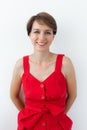 Confident business woman wearing red dress standing near white wall. Isolated portrait. Royalty Free Stock Photo