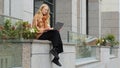 Confident business woman working outdoors young successful caucasian girl sitting near office building typing on laptop Royalty Free Stock Photo