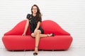 Confident businesslady in glasses. sexy teacher wear black elegant outfit. girl at red lips couch. love and romance Royalty Free Stock Photo