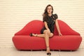 confident businesslady in glasses. sexy teacher wear black elegant outfit. girl at red lips couch. love and romance Royalty Free Stock Photo