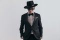 confident businessman in black tuxedo with hat holding hands in pockets Royalty Free Stock Photo