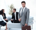 Confident businessman with briefcase standing in the lobby of the office. Royalty Free Stock Photo