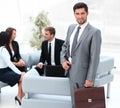 Confident businessman with briefcase standing in the lobby of the office. Royalty Free Stock Photo