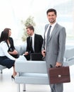 Confident businessman with briefcase standing in the lobby of the office. Royalty Free Stock Photo