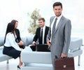 Confident businessman with briefcase standing in the lobby of the office. Royalty Free Stock Photo