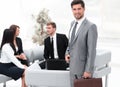 Confident businessman with briefcase standing in the lobby of the office. Royalty Free Stock Photo