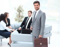 Confident businessman with briefcase standing in the lobby of the office. Royalty Free Stock Photo