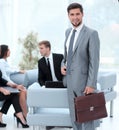 Confident businessman with briefcase standing in the lobby of the office. Royalty Free Stock Photo