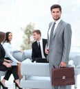 Confident businessman with briefcase standing in the lobby of the office. Royalty Free Stock Photo