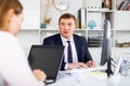 Confident businessman concentrated on work with computer in modern office