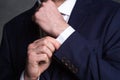 Confident businessman. Cropped shot of businessman in stylish suit straightens the sleeve.