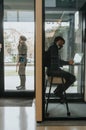 Confident businessman discussing innovative strategies for business growth in a private phone booth.