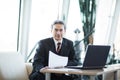 Confident businessman with documents on a laptop Royalty Free Stock Photo