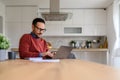 Confident businessman doing research over wireless computer on desk while sitting in home office