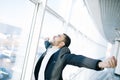 Confident businessman enjoys his success raising his hands and fists up