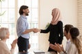 Executive shaking Asian muslim businesswoman hand at corporate meeting Royalty Free Stock Photo