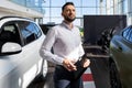 confident businessman filling out paperwork for buying a new car at a car dealership Royalty Free Stock Photo