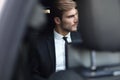 Confident businessman in full suit sitting in the luxe car