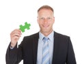 Confident businessman green jigsaw piece