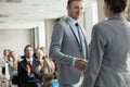 Confident businessman greeting public speaker during seminar Royalty Free Stock Photo