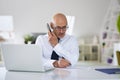 Executive businessman using mobile phone and laptop while working at the office Royalty Free Stock Photo