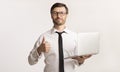 Confident Businessman Holding Laptop Gesturing Thumbs-Up, Studio Shot Royalty Free Stock Photo