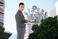 Confident businessman holding laptop by web design icons Royalty Free Stock Photo