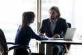 Confident businessman leader giving instruction to businesswoman at meeting