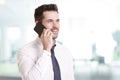 Confident businessman making a call while standing in the office Royalty Free Stock Photo