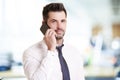 Confident businessman making a call while standing in the office Royalty Free Stock Photo