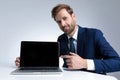 Confident businessman pointing to his laptop and smiling Royalty Free Stock Photo