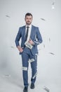 A confident businessman is seriously walking on the background of money. dressed in a suit standing on a white background Royalty Free Stock Photo