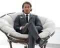 Confident businessman sitting in a large comfortable chair. Royalty Free Stock Photo