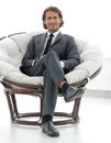 Confident businessman sitting in a large comfortable chair. Royalty Free Stock Photo