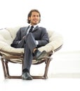 Confident businessman sitting in a large comfortable chair. Royalty Free Stock Photo