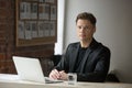 Confident businessman in suit sitting with laptop looking at cam Royalty Free Stock Photo