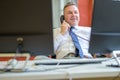 Confident businessman talking on a telephone in office Royalty Free Stock Photo