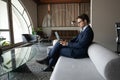 Confident businessman using laptop, sitting on couch in modern office Royalty Free Stock Photo