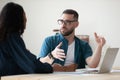 Confident businessman wearing glasses discussing project with colleague Royalty Free Stock Photo